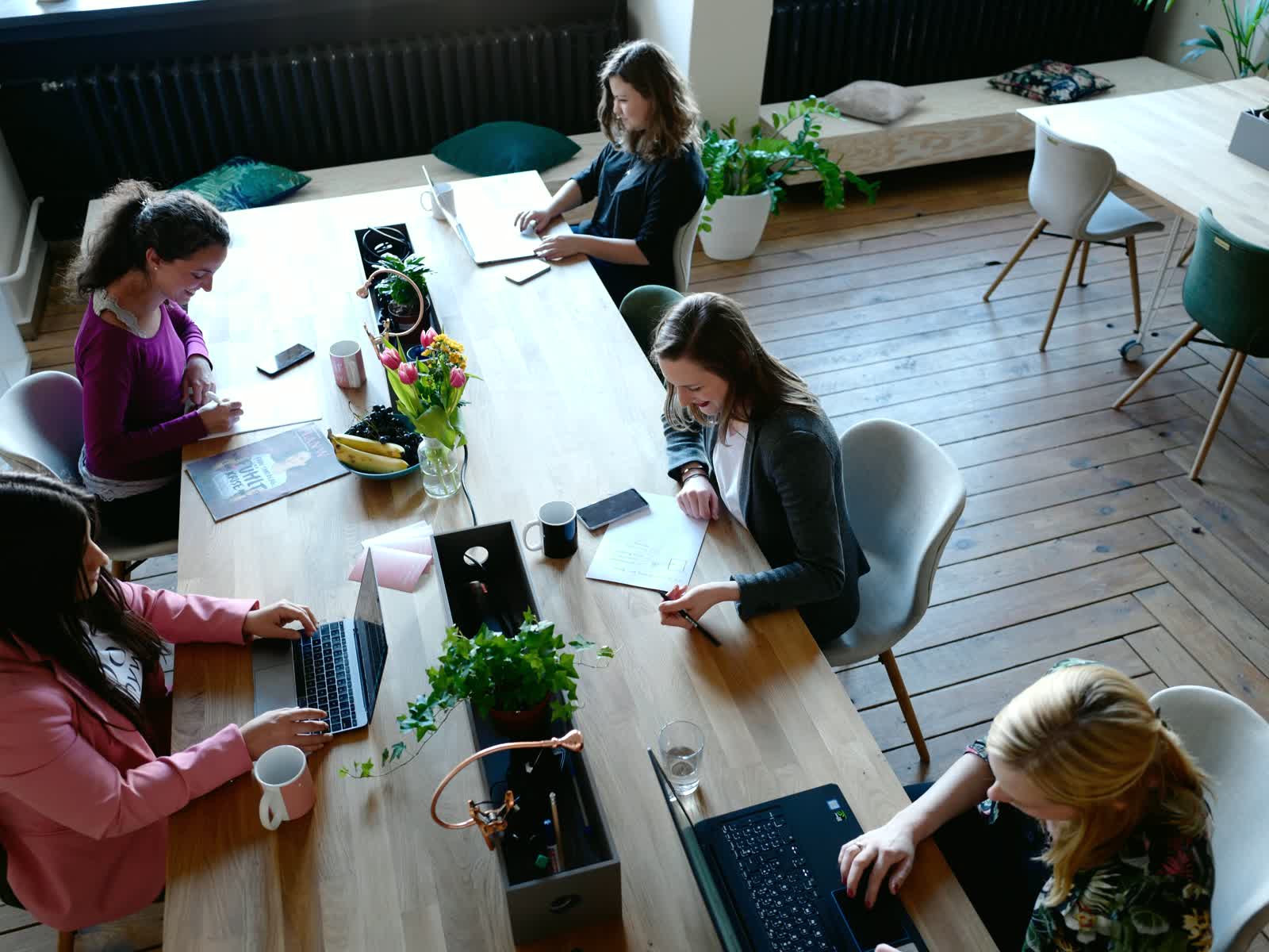 A team working on laptops around a shared table